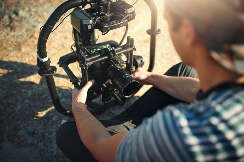 Videographer, hands and video camera outdoor for film production, photography and nature documentary. Cameraman, recording and prepare equipment for shooting and filmmaking behind the scenes on set.